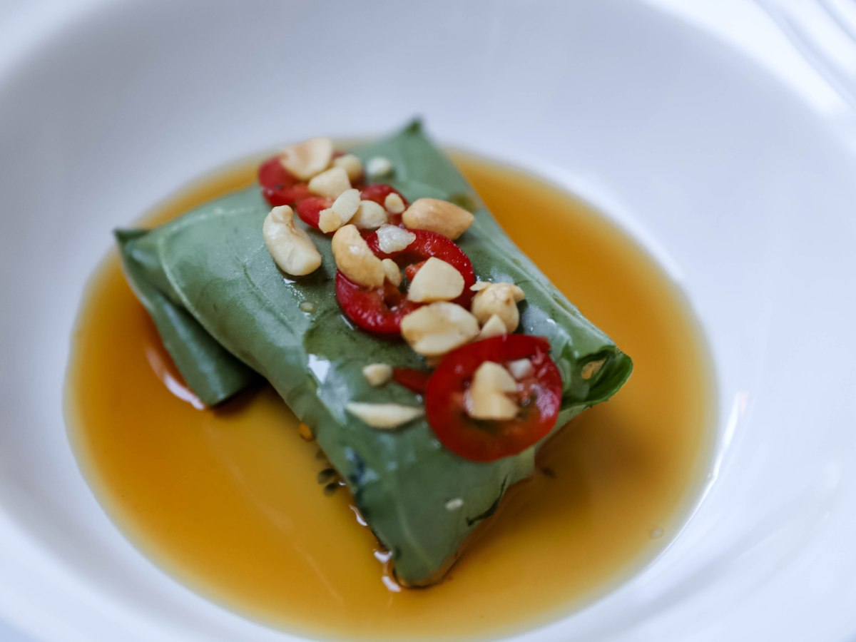 Hapje kerstmenu: gestoomde zeebaars in een pakketje van boerenkool met vissaus vinaigrette, chilipeper en pindanoten